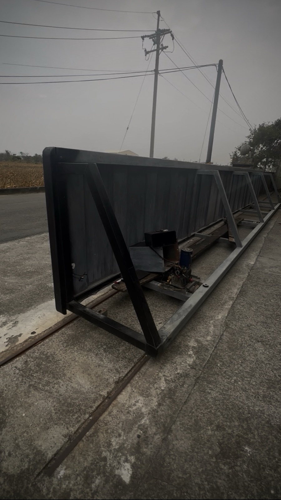 雙軌鏈式大門維修現場，業主反映碰停異常與雨天遙控失效。